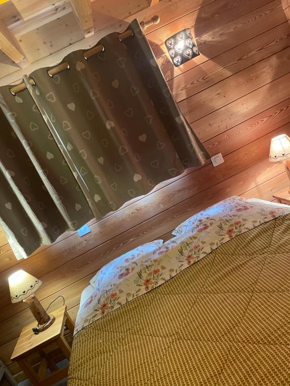 a bedroom with a bed and a wooden wall at Au Solé in Basse-sur-le-Rupt