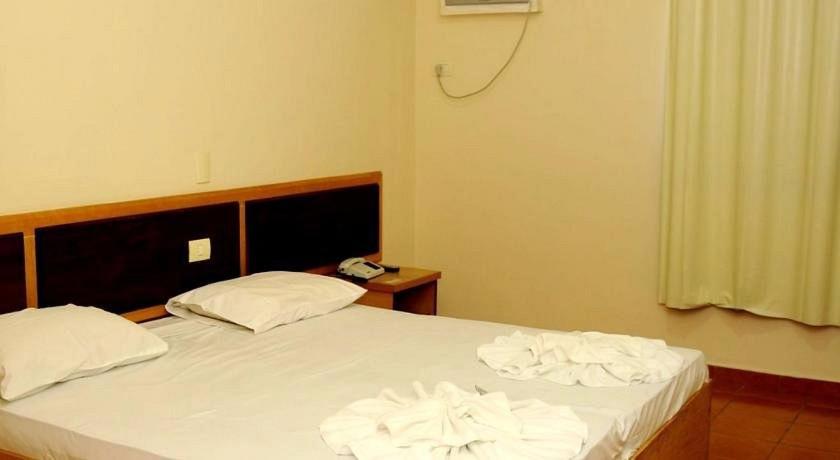 a bedroom with a bed with towels on it at Gutemberg Palace Hotel in Nova Serrana