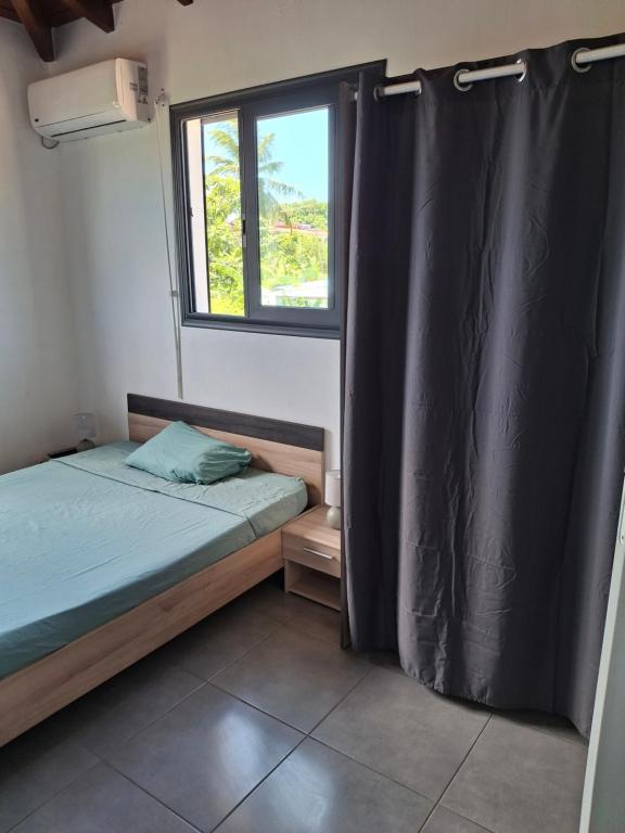 a small room with two beds and a window at Haut de maison T4 à Petit Canal in Petit-Canal