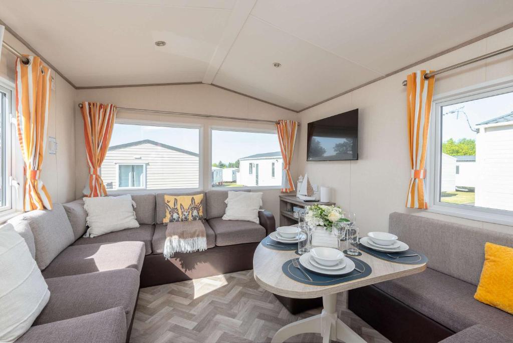 a living room with a couch and a table at 3 Bedroom Caravan-Seton Sands in Port Seton