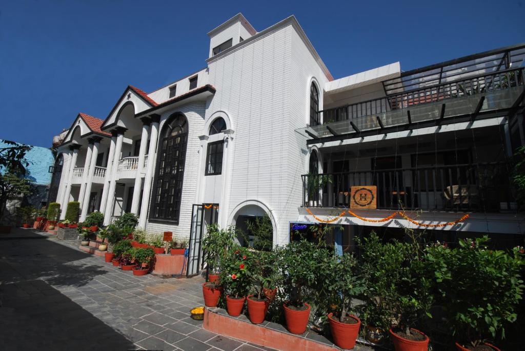 um edifício branco com vasos de plantas à sua frente em The Hush Nepal em Catmandu