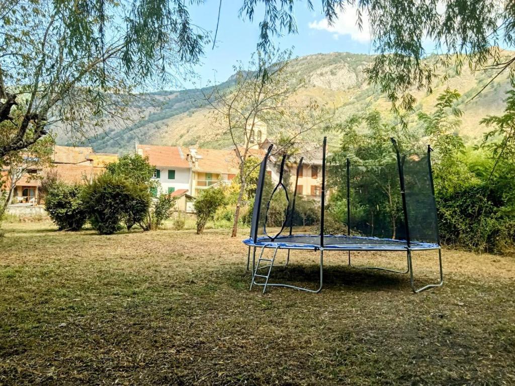a swing set in a yard with a mountain in the background at Maison avec jardin aux Cabannes - Ariège in Les Cabannes