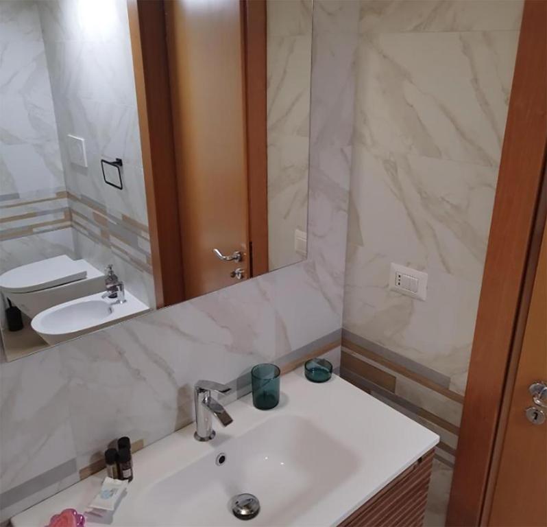 a bathroom with a sink and a mirror at Matī Guest House in Latiano