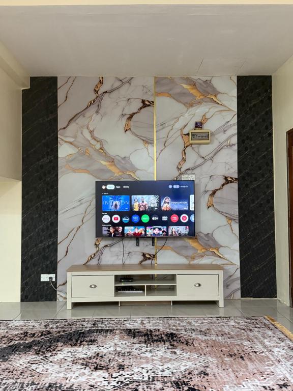 a living room with a flat screen tv on a wall at Coach homestay 2 in Kuantan