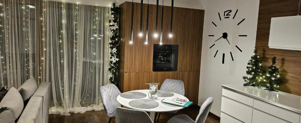 un comedor con una mesa y un reloj en la pared en Apartamenty Prestige Solina - jacuzzi i sauna w cenie, en Solina
