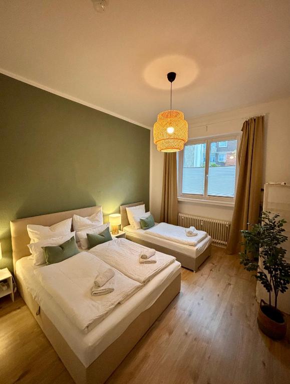 a bedroom with two beds and a large window at MaMaFeWo - EG Innenstadt - Privater Parkplatz - 2 Schlafzimmer - 24h Check-in - Highspeed WLAN - Streaming in Braunschweig