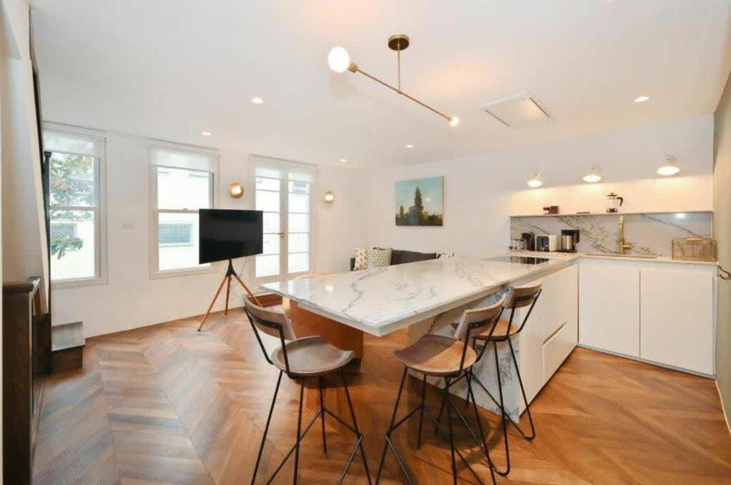 a kitchen with a table and chairs in a room at Contemporary 2-Bedroom Escape in Notting Hill in London