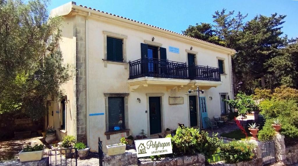 una casa bianca con un balcone sopra di Polytropon Studio ground floor a Cefalonia