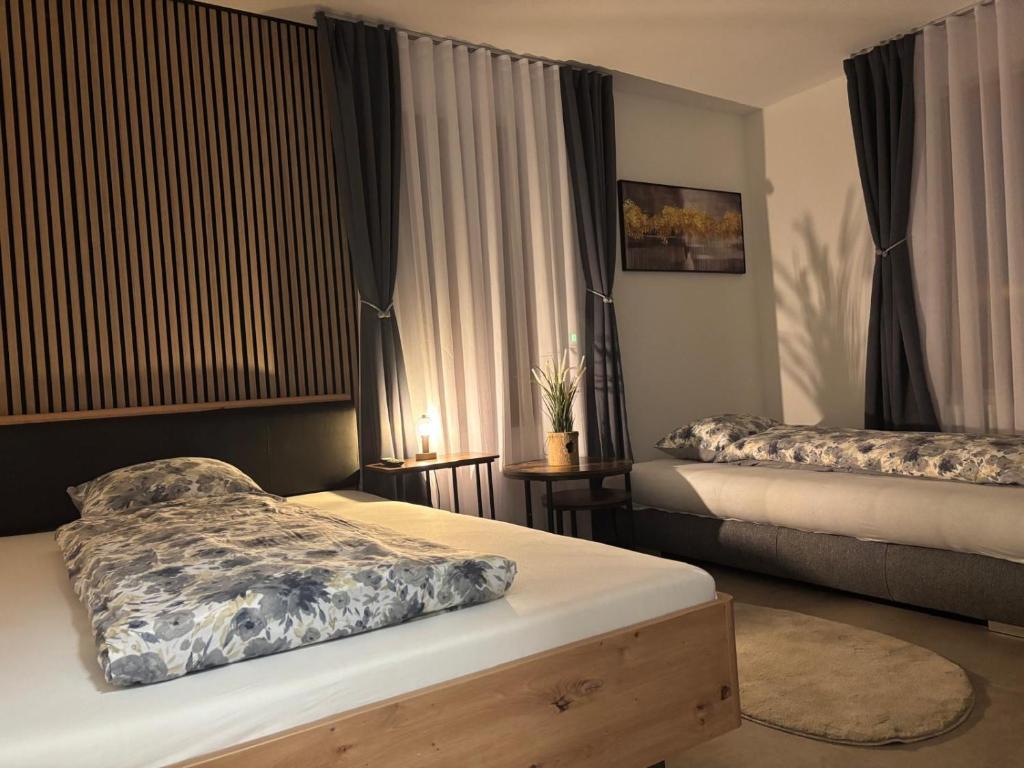 a bedroom with two beds and a window with curtains at Bellavista Home in Trimbach