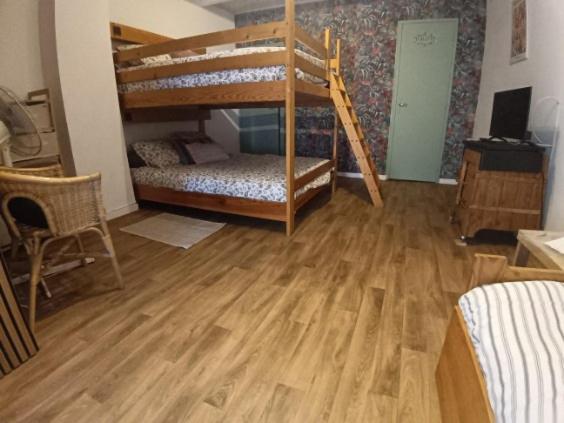 a room with two bunk beds and a wooden floor at Chambre privée chez l'habitant, Les Maisons de Gaia in Tuchan