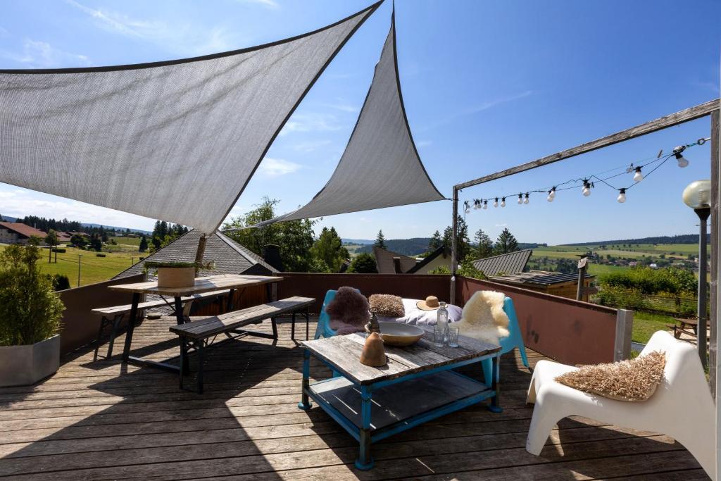d'une terrasse avec des chaises et des tables. dans l'établissement Appartement au cœur des montagnes, à Métabief