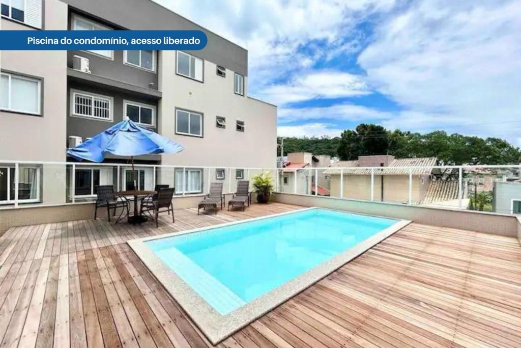 an apartment patio with a swimming pool and a table at Apartamento no Coração de Bombinhas in Bombinhas