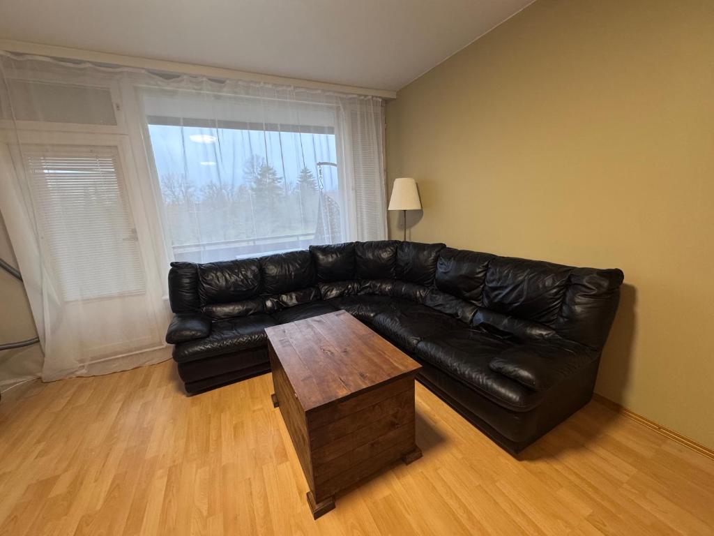 a black leather couch in a living room with a coffee table at Park View Apart in Kouvola