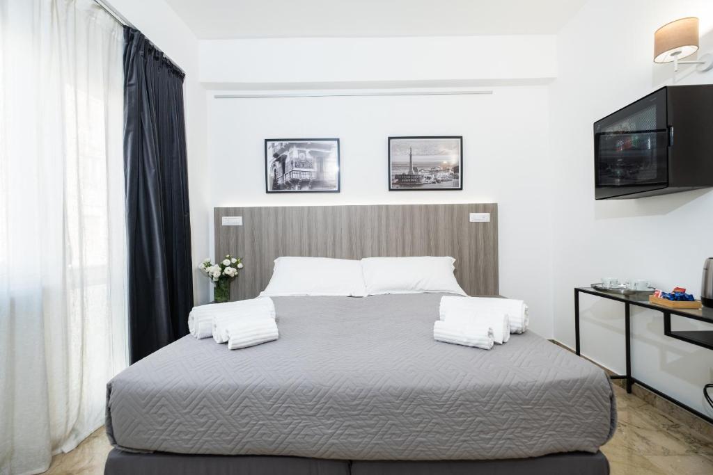 a bedroom with a large bed with two pillows at Talìa Rooms And Gallery in Messina