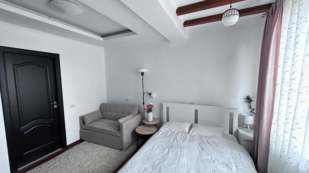 un dormitorio con una cama y una silla en Casa Joy, en Bucarest