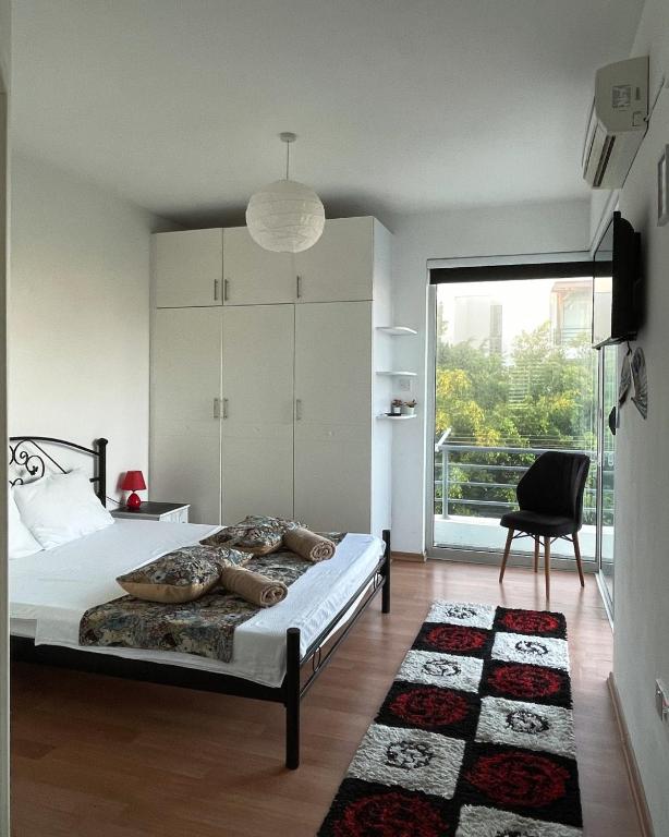 a bedroom with a bed and a chair and a window at Rix Palm Apartments in Kyrenia
