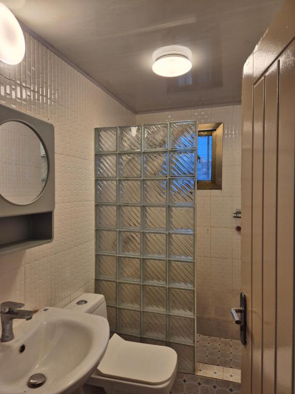 a bathroom with a toilet and a sink and a shower at Palm and Pillow in Freetown