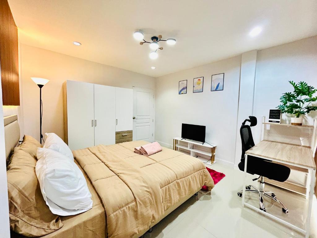 a bedroom with a large bed and a desk at Vibe Phuket Relax in Town in Phuket Town