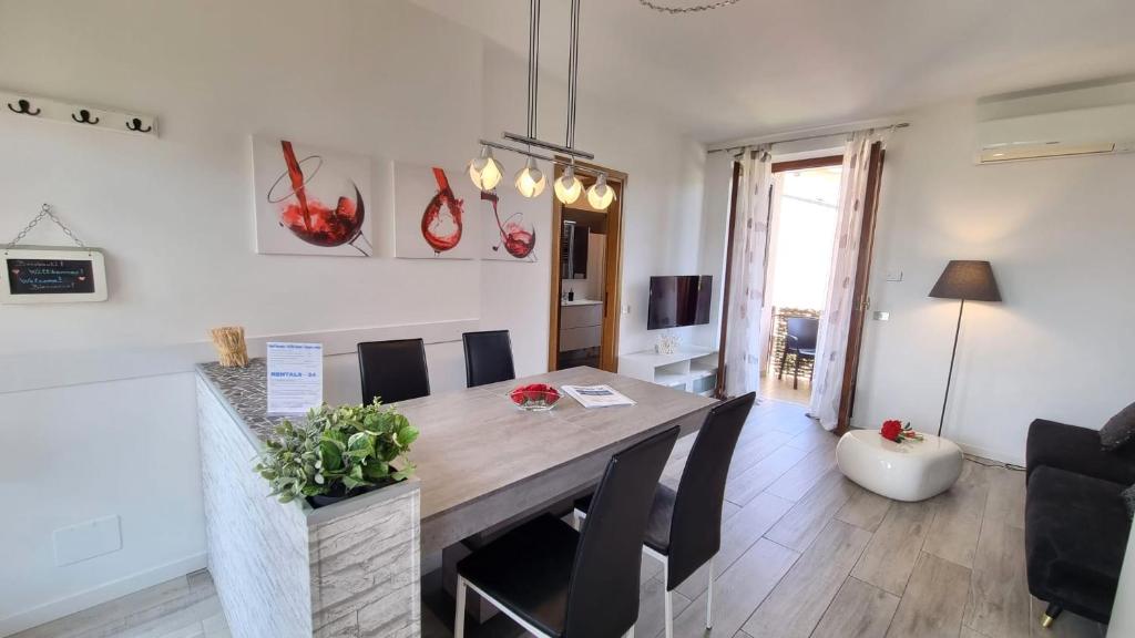 a dining room with a table and a living room at Sole del Garda 10 in Lazise