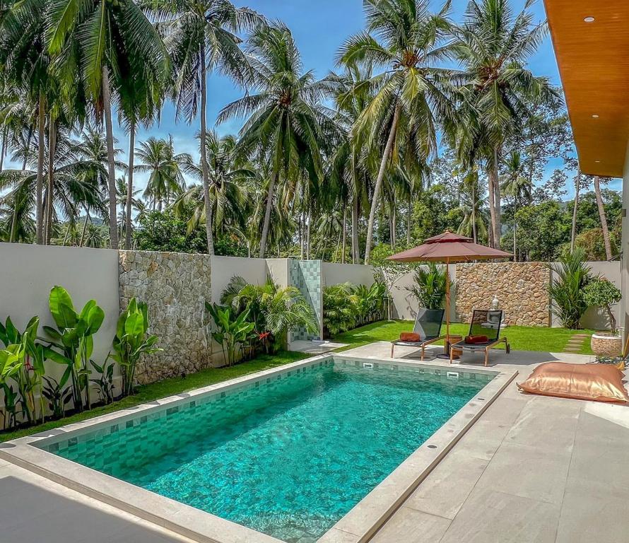een zwembad in een achtertuin met palmbomen bij Villa Souimanga 2Bed Balinese style Garden & Pool in Mae Nam