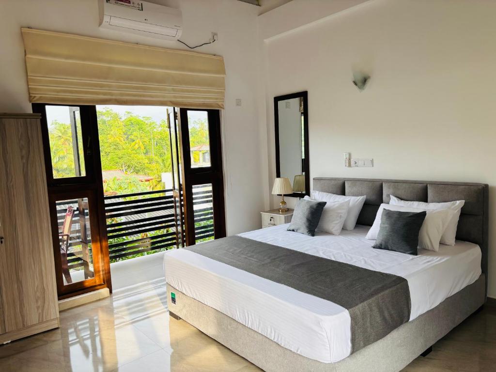 a bedroom with a large bed and a balcony at Villa southern coast in Kamburugamuwa