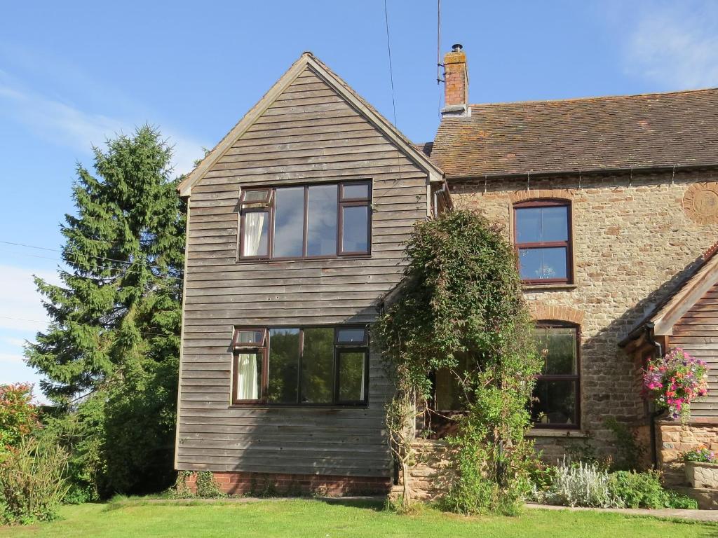 an old brick house with black windows at New House Farm Annexe in Neenton