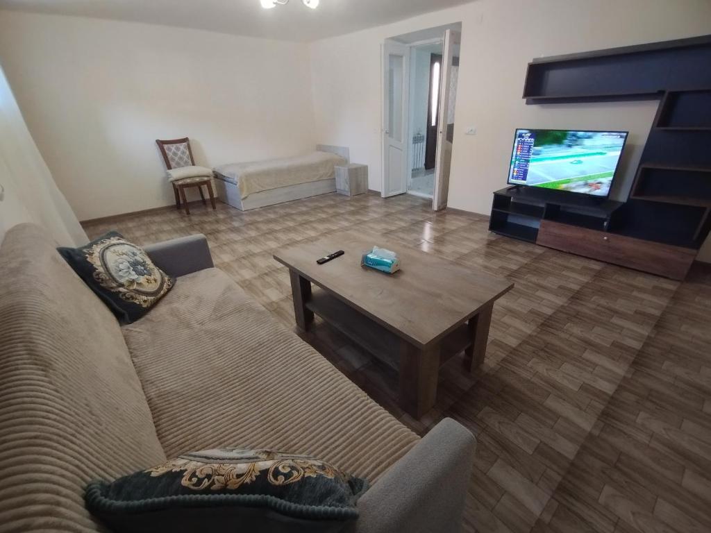 Una sala de estar con un sofá y un televisor. en Guest House, en Gyumri