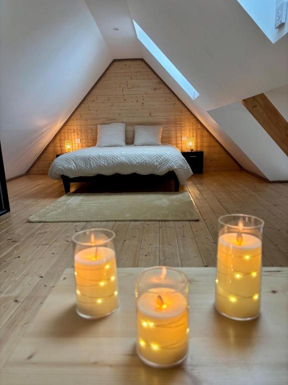four candles on a table in a room with a bed at Le Nid de Schatzi in Haguenau