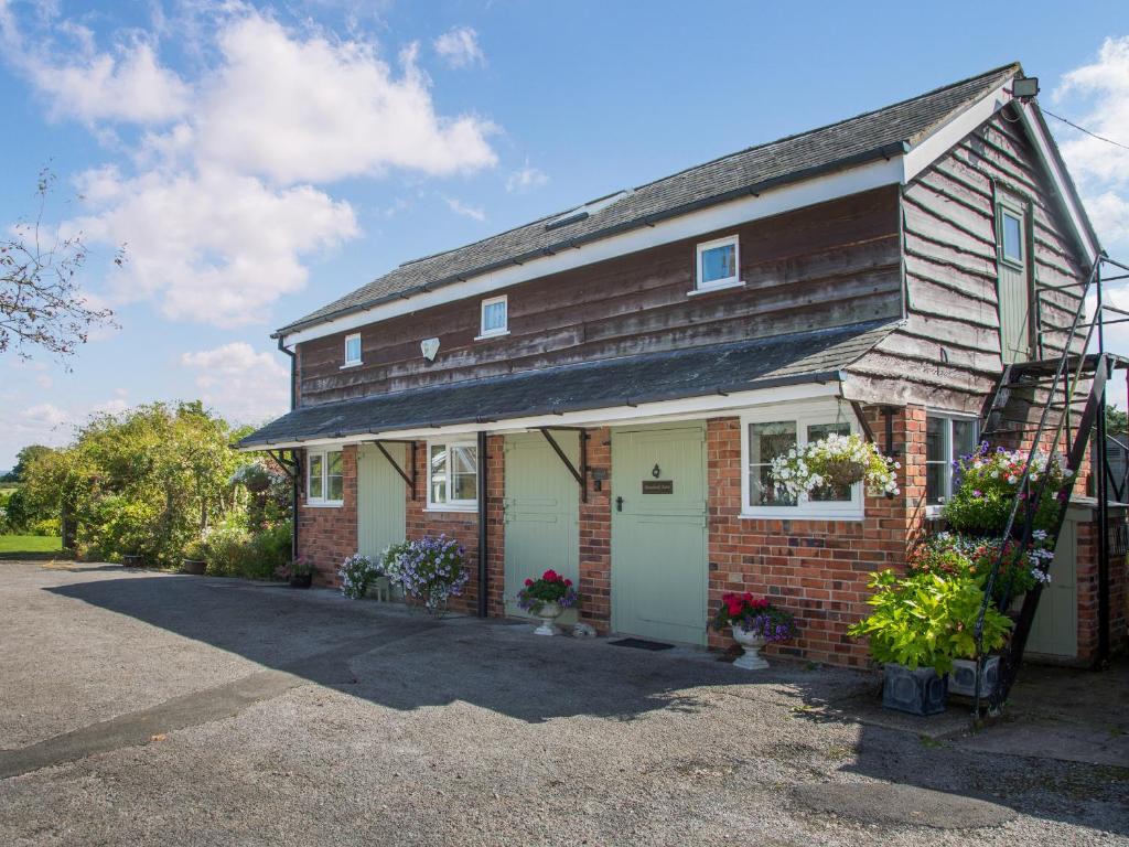a small brick house with a white garage at Broadoak Barn in Ellesmere