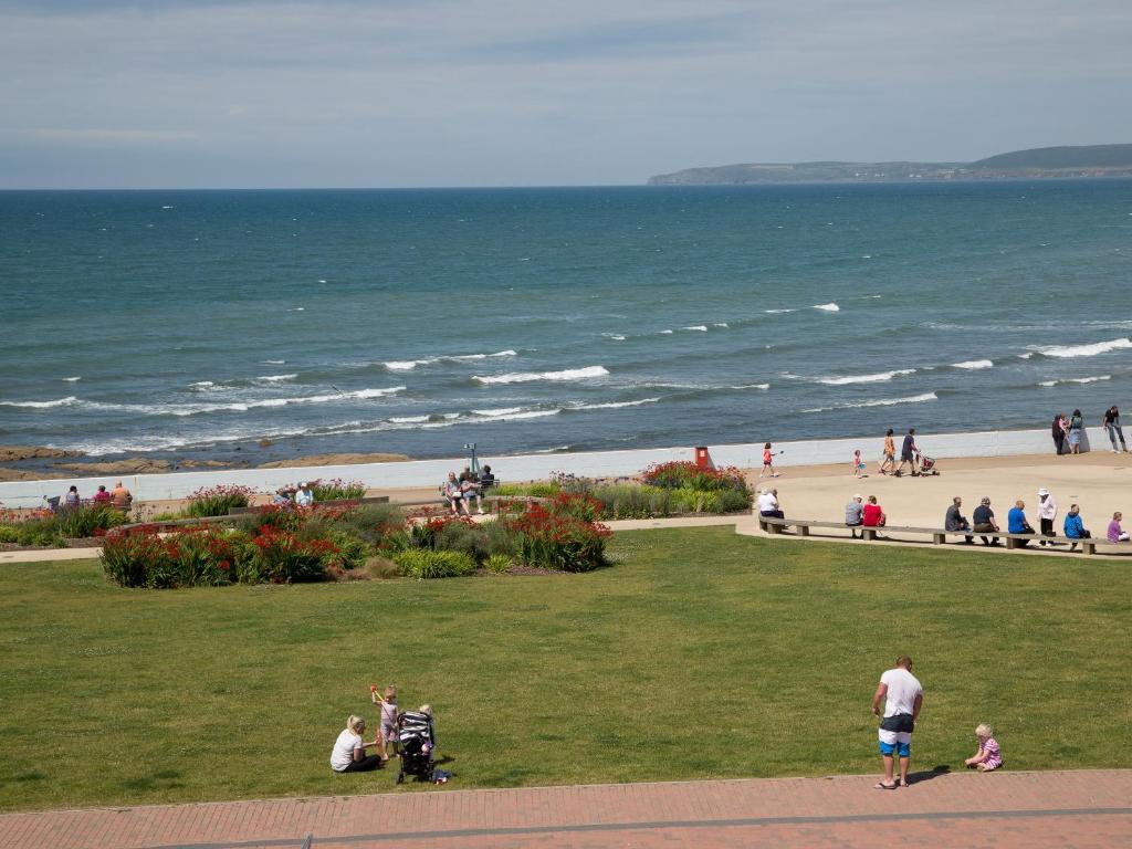 a group of people on the beach near the ocean at Apartment 11 - Latitude 51 in Westward Ho
