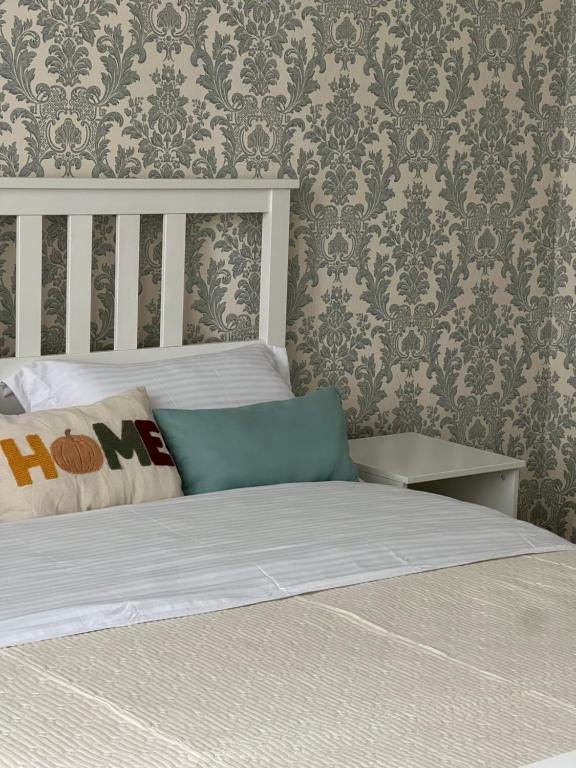 a bedroom with a bed and a wall with wallpaper at Квартира в центре города in Astana