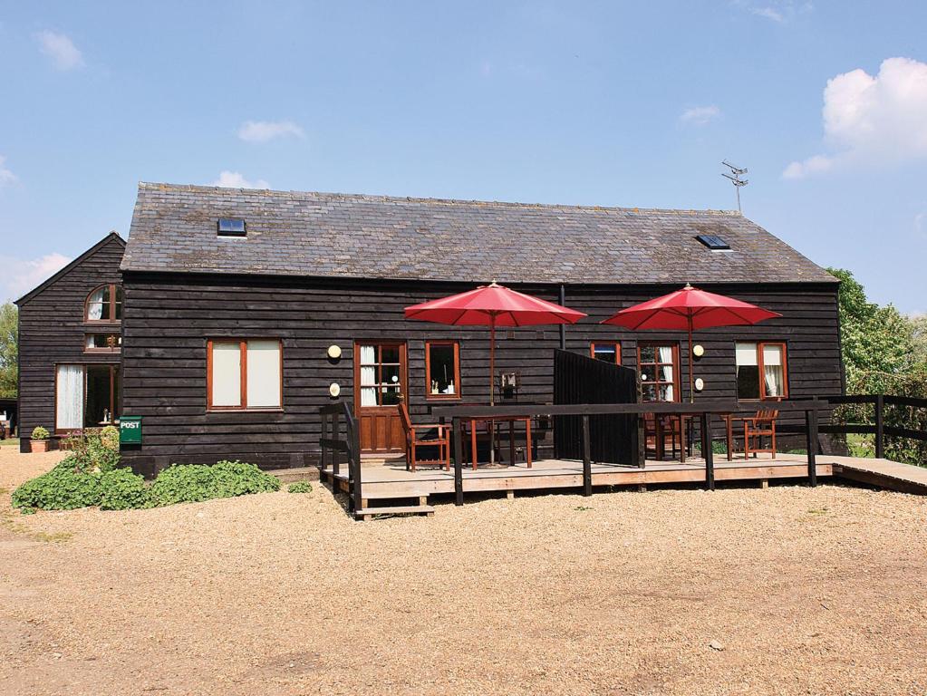 a house with tables and umbrellas in front of it at Swan in Welney