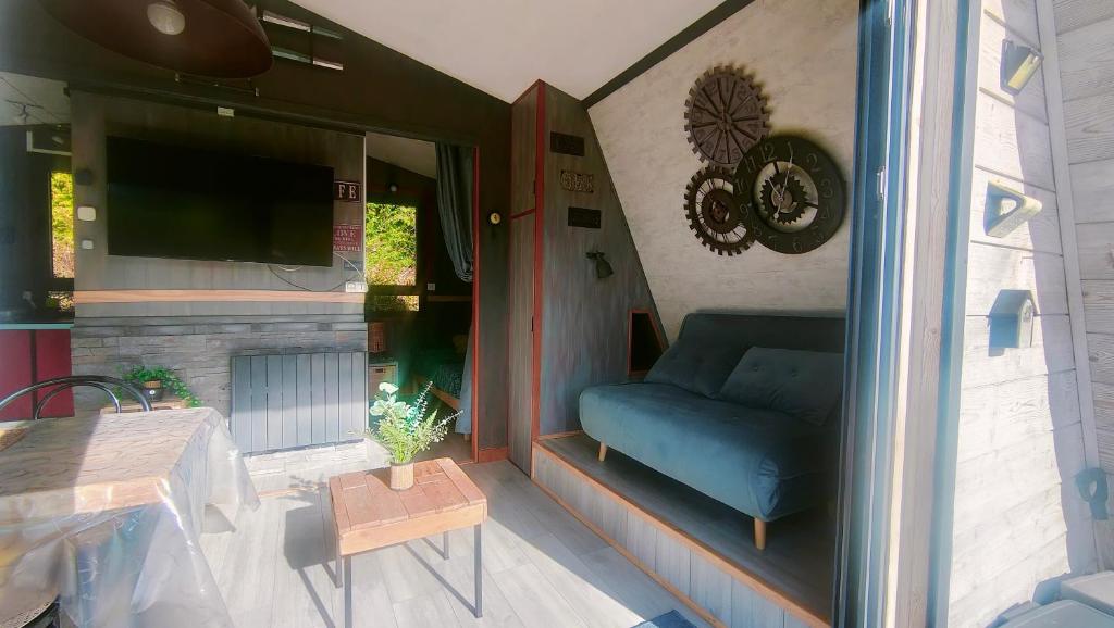a porch with a blue couch and a fireplace at Chalet de détente in Métabief