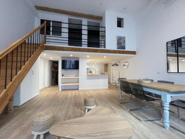 a living room with a staircase and a table and chairs at Atelier Marius ROCHE in Marseille