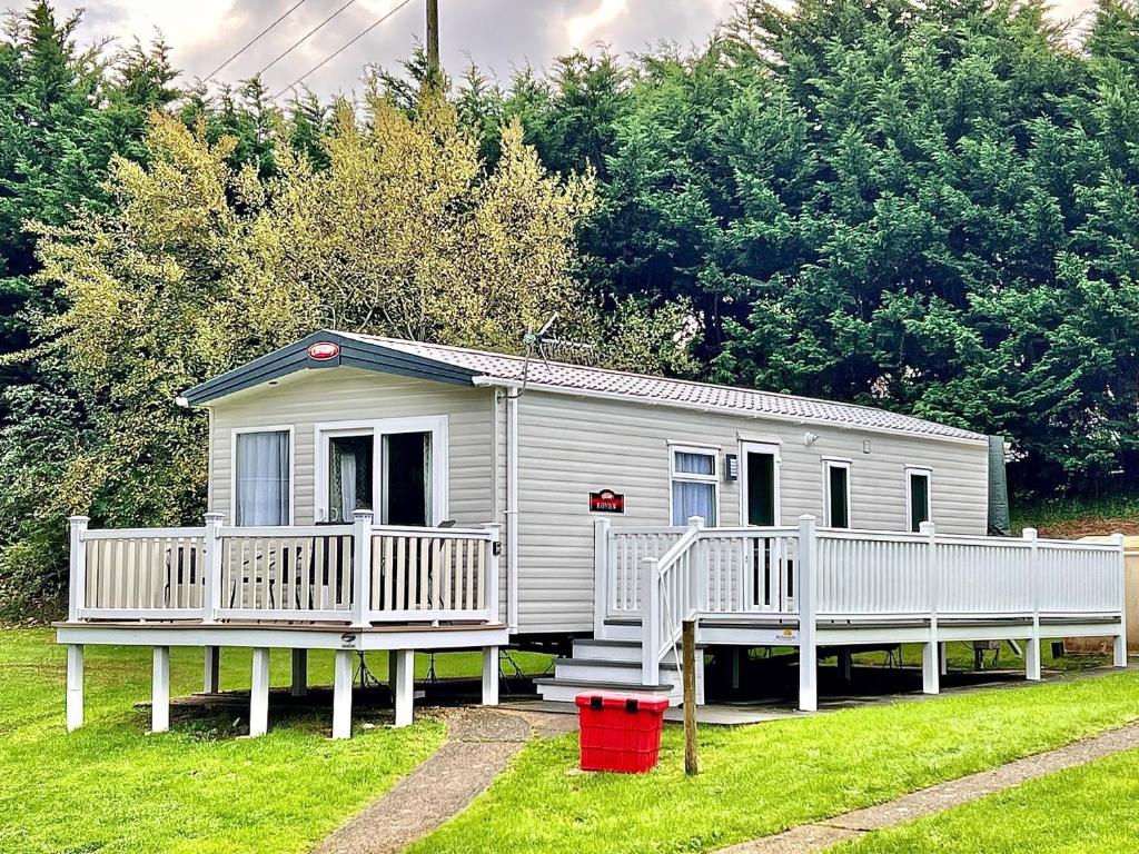 a small white house with a porch and stairs at Isle of Wight Caravan in Shanklin