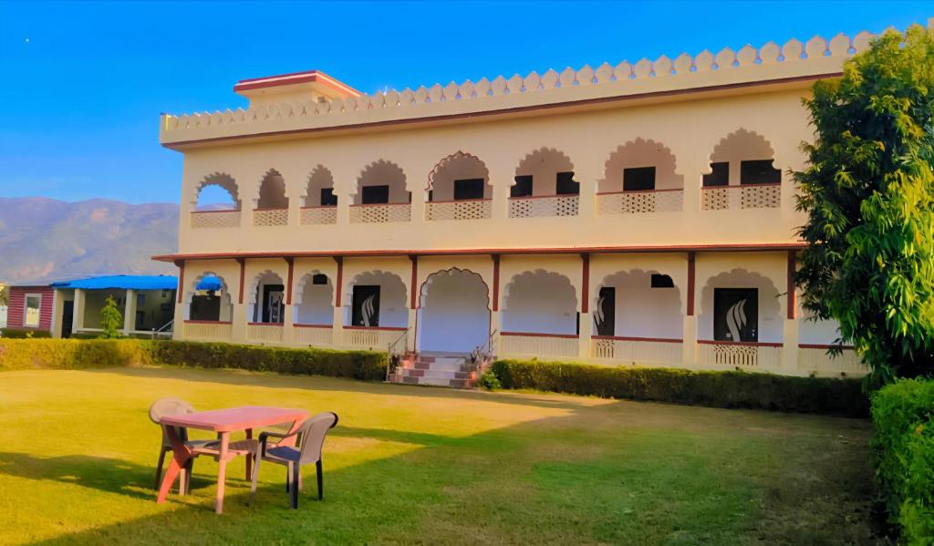 um edifício com uma mesa e cadeiras no pátio em The Great Meva Palace Pushkar em Pushkar