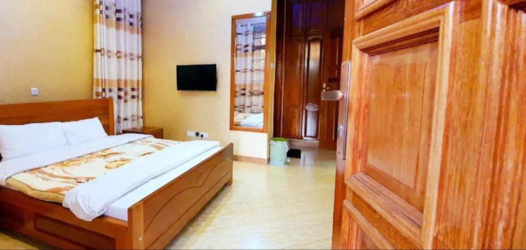 a bedroom with a bed and a wooden door at Cape Villa in Arusha