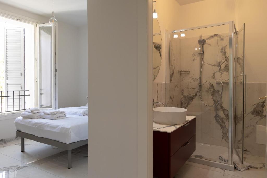 a bathroom with a bed and a shower and a sink at Astoria Guest House in Ravenna