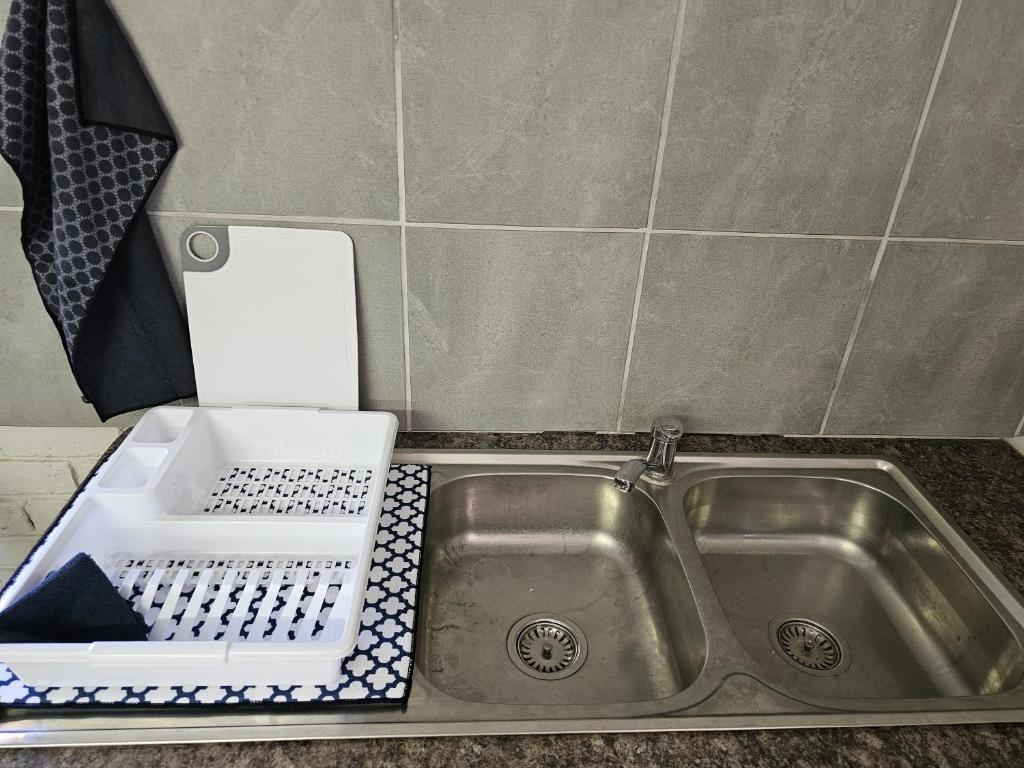 a kitchen sink with a dish drying rack next to it at Lalapanzi Accommodation in Vosburg