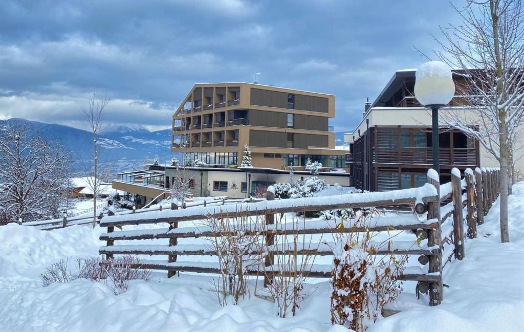 a building in the snow in front of a fence at Hotel Fischer in Bressanone