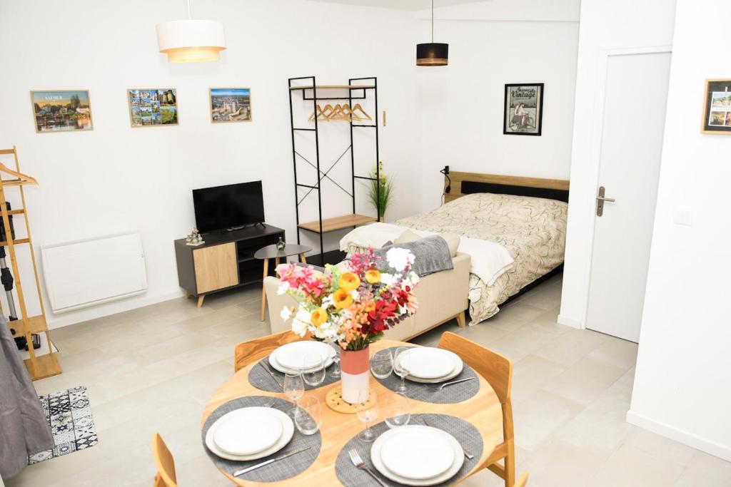 a living room with a table and a bed at La Manutention in Saumur
