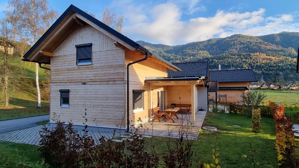 ein kleines Haus mit einer Terrasse im Hof in der Unterkunft Felsenfest Cottage in Kötschach