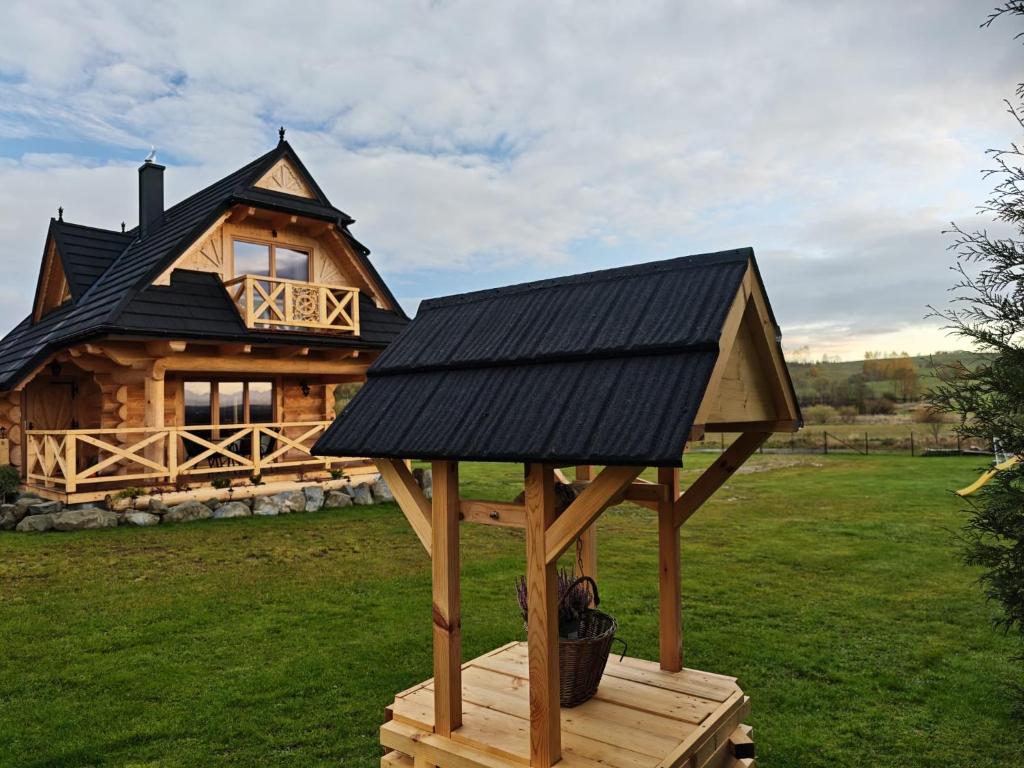 a house with a black roof and a gazebo at Domek z Sercem in Pieniążkowice