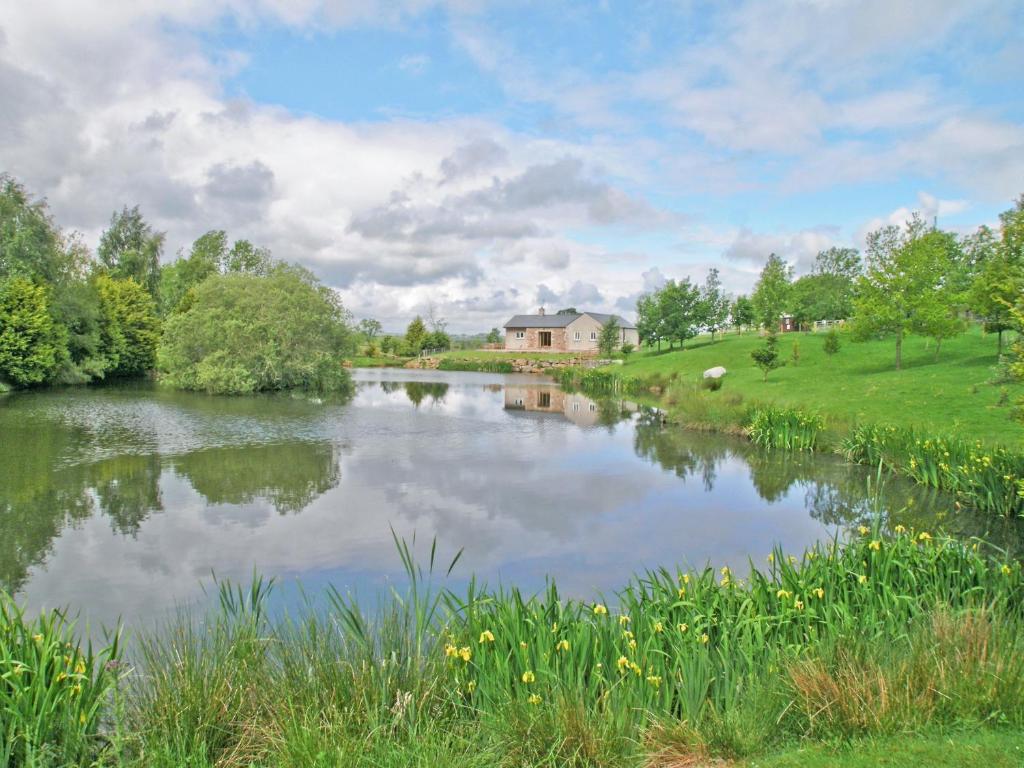 a view of a river with a house in the background at Swallows Nest in Soulby