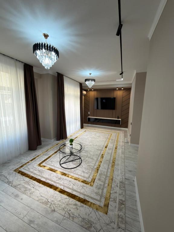 a living room with a table and a television at Туркестан VIP КАРАВАН in Türkistan