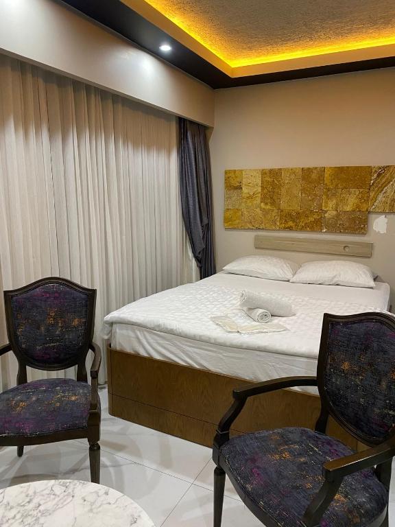 伊斯坦布尔paradise hotel的一间带一张床和两把椅子的酒店房间