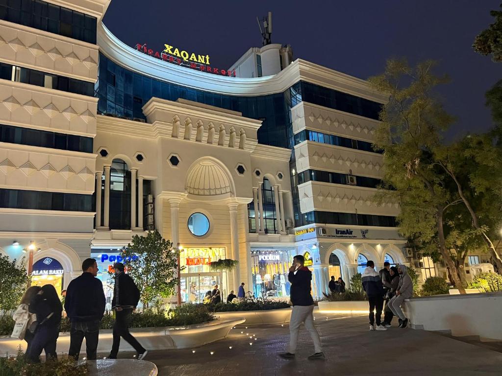 a group of people standing outside of a building at night at Baku Center inn NS in Baku