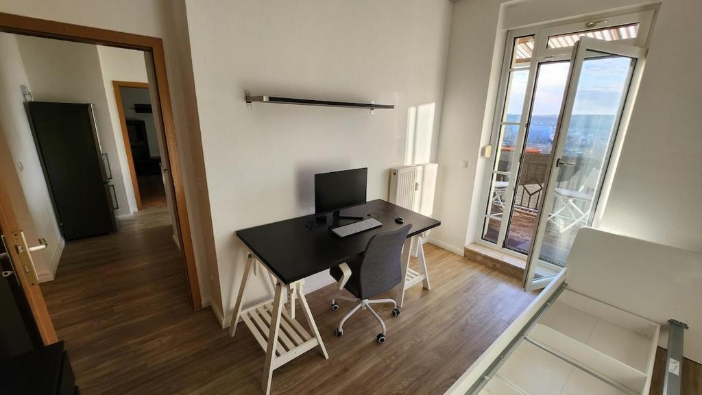 a room with a desk with a computer on it at Ruhiger Flussblick vom Balkon in Niederdorla