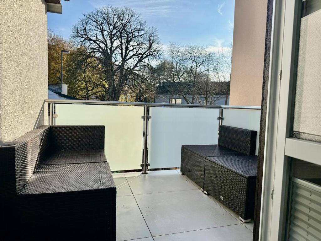 einen Balkon mit 2 Stühlen und Blick auf ein Gebäude in der Unterkunft Ewelina's Fachwerk-Appartment 2 in Sundern