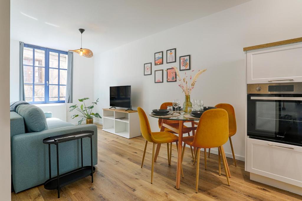 a kitchen and living room with a table and chairs at L'Escapade Médiévale Appartement neuf in Josselin